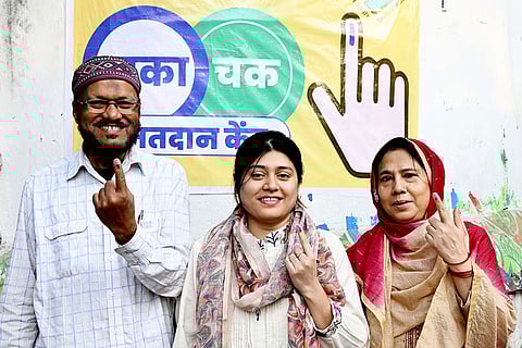 People show their fingers marked with indelible ink after casting votes at a polling station during the first phase of Bihar Assembly elections, in Patna.