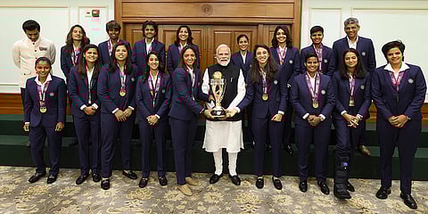 Prime Minister Narendra Modi holding the ICC Women's Cricket World Cup winner's trophy as he poses for a photograph with the winning Indian women cricket team in New Delhi. 