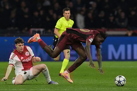 Ajax's James McConnell tackles Galatasaray's goalkeeper Gunay Guvenc during the Champions League between Ajax and Galatasaray in Amsterdam, Netherlands.