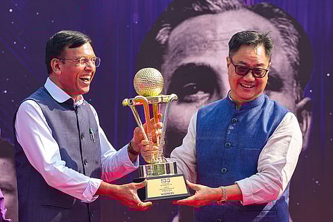 Union Minister for Sports Mansukh Mandaviya and Union Minister Kiren Rijiju poses with the Men's Junior Hockey World Cup trophy during the Hockey India centenary celebrations, at Major Dhyan Chand National Stadium, in New Delhi. The nationwide tour of the trophy, which will travel across 20 cities in the country, officially kicked off on Friday.