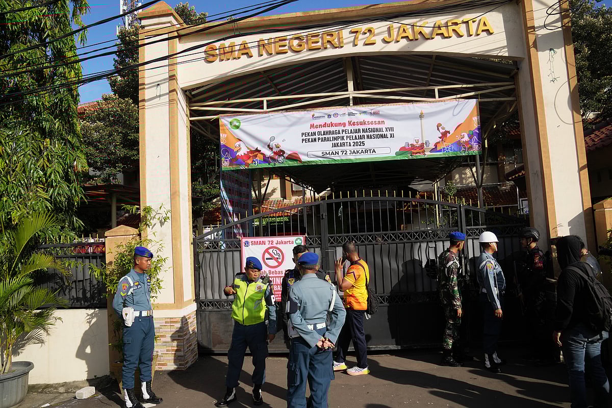 Police officers and military personnel stand guard at the gate of a school where explosions reportedly occurred, in Jakarta, Indonesia, Friday, Nov. 7, 2025 - . (AP Photo/Dita Alangkara)