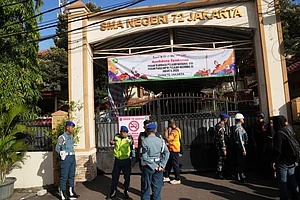 . (AP Photo/Dita Alangkara) : Police officers and military personnel stand guard at the gate of a school where explosions reportedly occurred, in Jakarta, Indonesia, Friday, Nov. 7, 2025