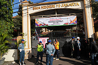 . (AP Photo/Dita Alangkara) : Police officers and military personnel stand guard at the gate of a school where explosions reportedly occurred, in Jakarta, Indonesia, Friday, Nov. 7, 2025