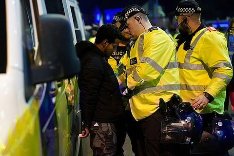 Police officers detain a pro-Palestinian protester for setting off a firework in a public place outside Villa Park during the Europa League soccer match between Aston Villa and Maccabi Tel Aviv in Birmingham, England.