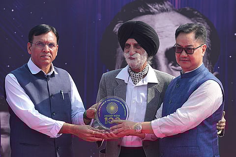 Union Sports and Youth Affairs Minister Mansukh Mandaviya, left, and Union Minister Kiren Rijiju, right, felicitate former hockey player Brigadier Harcharan Singh (Retd.) during an event marking 100 years of Indian Hockey, at Major Dhyan Chand National Stadium, in New Delhi.