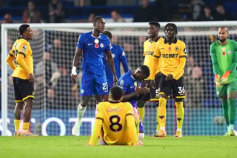 Chelsea's Moises Caicedo, center, celebrates while Wolverhampton Wanderers players look dejected after the final whistle during the English Premier League soccer match in London.