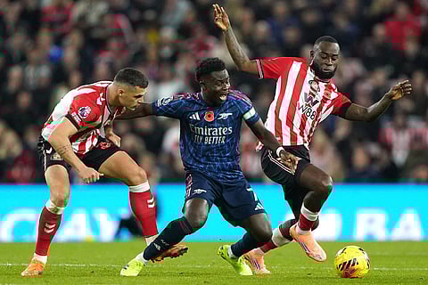 Arsenal's Bukayo Saka (centre) battles for the ball with Sunderland's Granit Xhaka (left) and Lutsharel Geertruida during the English Premier League soccer match between Arsenal and Sunderland, in Sunderland, England.