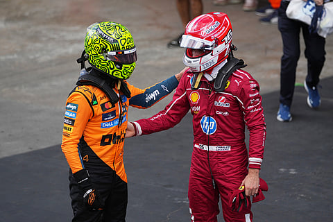 First-place finisher McLaren driver Lando Norris of Britain, left, and third-place finisher Ferrari driver Charles Leclerc of Monaco celebrate during the qualifying session ahead of the Brazilian Formula One Grand Prix at the Interlagos race track, in Sao Paulo.
