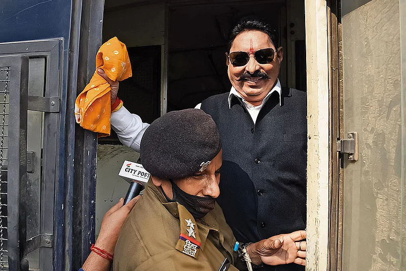 RJD MLA Anant Singh being detained by a police official on November 25, 2020, in Patna