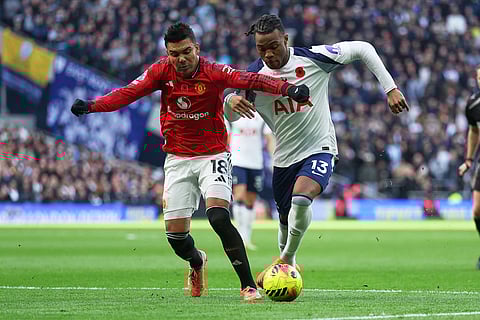 Manchester United's Casemiro, left, challenges for the ball with Tottenham's Destiny Udogie during the English Premier League soccer match between Tottenham Hotspur and Manchester United in London, England.