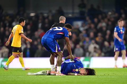 Chelsea's Malo Gusto lies on the pitch in pain following a challenge, during the English Premier League soccer match between Chelsea and Wolverhampton Wanderers in London.