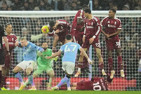 Manchester City's Phil Foden, centre, takes a free kick during the English Premier League soccer match between Manchester City and Liverpool in Manchester, England.