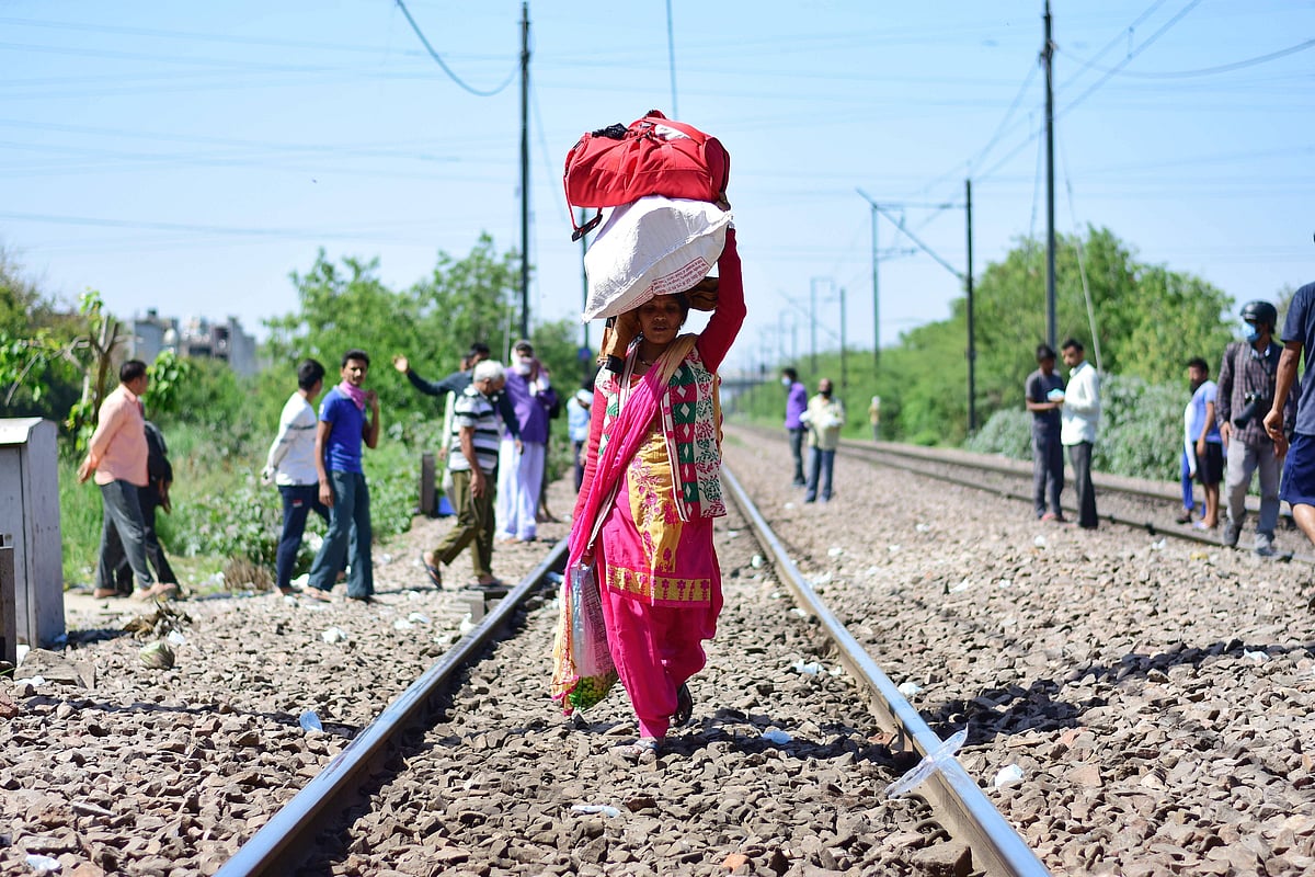 Delhi, India: A woman with her belongings walking towards Laxmi Nagar train station leaving for her village. - Source: IMAGO / Zuma Press Wire