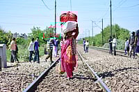 Source: IMAGO / Zuma Press Wire : Delhi, India: A woman with her belongings walking towards Laxmi Nagar train station leaving for her village.