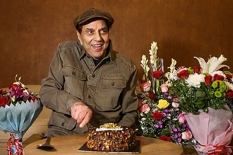 In this file photo, actor Dharmendra cuts a cake to celebrate his 87th birthday, in Mumbai. Dharmendra, who has been in hospital for several days, is in a serious condition but is stable, an industry insider said.