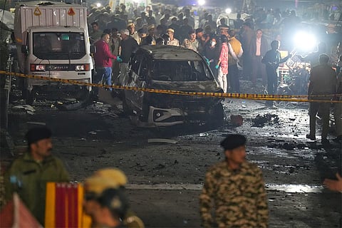 Police, security and rescue personnel at the site after a blast in a parked car near Red Fort left multiple vehicles in flames, in New Delhi.