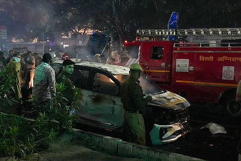 Police personnel at the spot after a blast occurred in a parked car near Red Fort, leaving multiple vehicles in flames, in New Delhi.