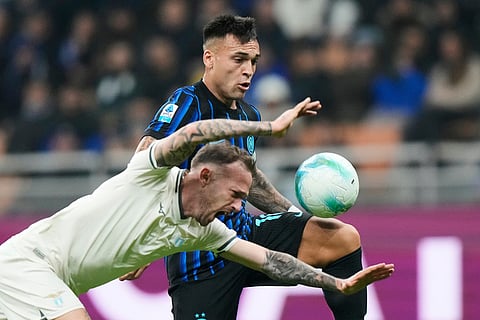 Inter Milan's Lautaro Martinez, rear, and Lazio's Manuel Lazzari vie for the ball during a Serie A soccer match between Inter Milan and Lazio, in Milan, Italy.