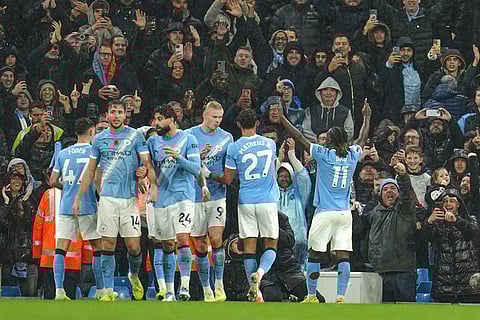 Manchester City's Jeremy Doku, right, celebrates after scoring his side's third goal during the English Premier League soccer match between Manchester City and Liverpool in Manchester, England.