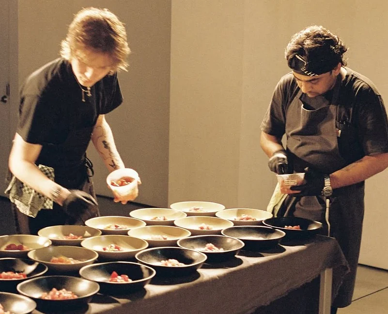 Two chefs preparing food in bowls