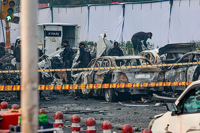 Charred remains of vehicles at a cordoned off area following a blast that occurred near Red Fort Metro Station on Monday, killing at least nine people and gutting several vehicles, in New Delhi. - | Photo: PTI
