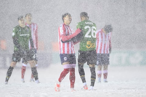 Atletico Ottawa's David Rodríguez, center left, and Cavalry FC's Shamit Shome (26) laugh in the snow during second-half Canadian Premier League finals soccer match action in Ottawa, Ontario.