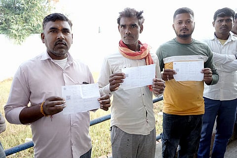 In this image, Voters show their documents during the second and final phase in the Bihar Assembly elections, in Rohtas.