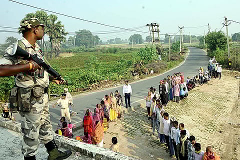 A security personnel stands guard at a polling station during the second and final phase of the Bihar Assembly elections, in Jehanabad.
