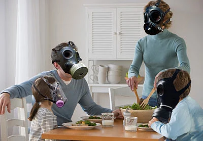 a family at dining table wearing hazardous air masks