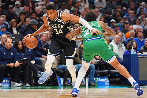 Milwaukee Bucks forward Giannis Antetokounmpo (34) drives past Dallas Mavericks forward P.J. Washington during the first half of an NBA basketball game in Dallas.