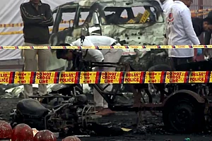 | Photo: PTI : Charred remains of vehicles amid a cordoned off area following a blast that occurred near Red Fort Metro Station on Monday, killing at least nine people and gutting several vehicles, in New Delhi.