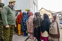 PTI : Budgam: Security personnel keep vigil as voters wait to cast their votes at a polling station during the Budgam assembly constituency bypoll, in Budgam district, Jammu and Kashmir, Tuesday, Nov. 11, 2025. 