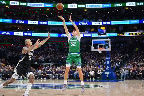 Dallas Mavericks forward Cooper Flagg (32) shoots against Milwaukee Bucks forward Kyle Kuzma (18) during the second half of an NBA basketball game in Dallas.