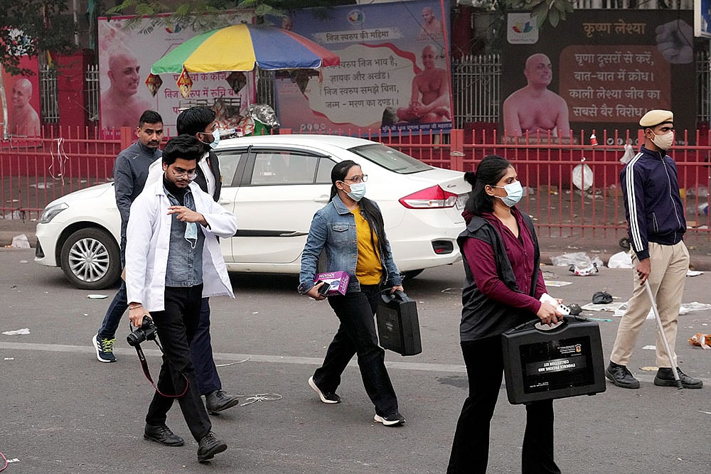 Forensic officials at the site in the aftermath of the blast that occurred near Red Fort Metro Station on Monday, killing at least nine people and gutting several vehicles, in New Delhi. - Photo: PTI/Kamal Kishore