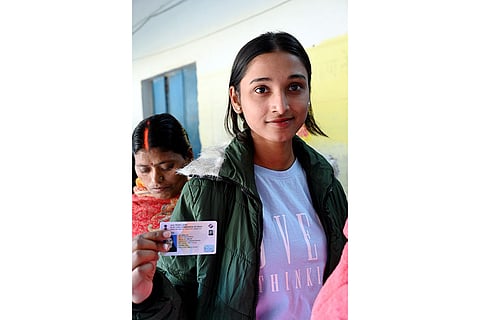 A first time voter shows her ID card at a polling station during the second and final phase of the Bihar Assembly elections, in Gaya.