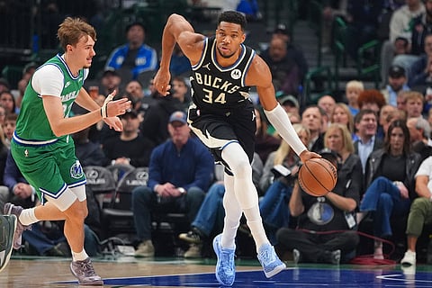 Milwaukee Bucks forward Giannis Antetokounmpo (34) dribbles against Dallas Mavericks forward Cooper Flagg during the first half of an NBA basketball game in Dallas.