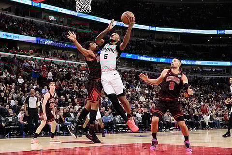 San Antonio Spurs guard Stephon Castle (5) drives to the basket against Chicago Bulls guard Tre Jones, center left, during the second half of an NBA basketball game in Chicago.