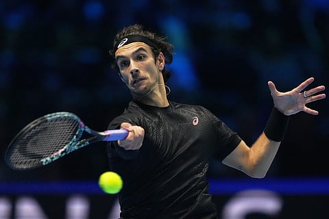 Italy's Lorenzo Musetti returns the ball to Australia's Alex de Minaur during their tennis match of the ATP World Tour Finals, in Turin, Italy.
