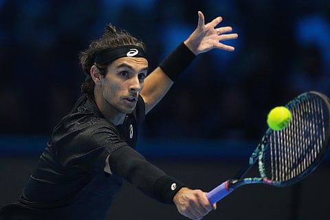 Italy's Lorenzo Musetti returns the ball to Australia's Alex de Minaur during their tennis match of the ATP World Tour Finals, in Turin, Italy.