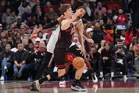 San Antonio Spurs forward Victor Wembanyama, right, tries to steal the ball from Chicago Bulls forward Matas Buzelis, left, during the second half of an NBA basketball game in Chicago.