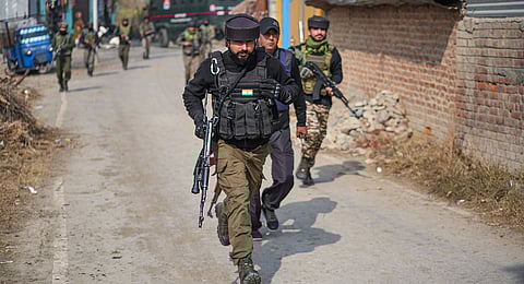 Police personnel cordon off an area while conducting a raid at a residential property at Karimabad village, in Pulwama district of Jammu and Kashmi. The property is reportedly linked to members of the banned Jamaat-e-Islami organisation, following the Delhi blast probe.