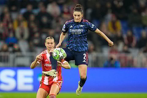 Arsenal's Emily Fox leaps for the ball in front of Bayern's Klara Buehl during the women's Champions League opening phase soccer match between FC Bayern Munich and Arsenal FC in Munich, Germany.