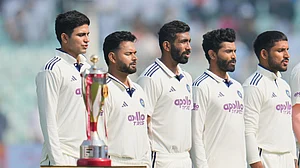 (AP Photo/Aijaz Rahi) : India's captain Shubman Gill, left, and teammates stand for their national anthem prior to the start of the first cricket test match between India and South Africa in Kolkata, India, Friday, Nov. 14, 2025.
