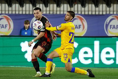 Albania's Arber Hoxha takes a shot past Andorra's Biel Borra, right, during a World Cup 2026 group K qualifying soccer match between Andorra and Albania in Encamp, Andorra.