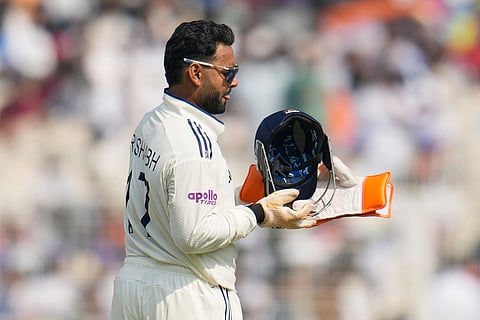India's wicketkeeper Rishabh Pant wears his gear to take his position on the first day of the first cricket test match between India and South Africa in Kolkata.