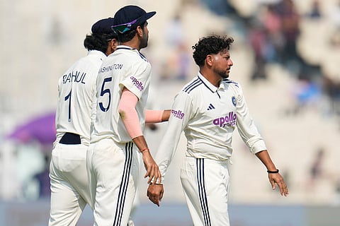 India's Kuldeep Yadav, right, celebrates with teammates after the dismissal of South Africa's captain Temba Bavuma on the first day of the first cricket test match between India and South Africa in Kolkata.