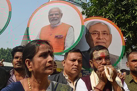 Supporters of National Demoractic Alliance (NDA) celebrate the early leads in Bihar state election results in front of the photographs of their leaders Nitish Kumar of Janata Dal (United), right, and Prime Minister Narendra Modi of Bharaiya Janata party, center, in Patna.