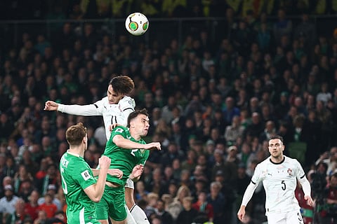 Portugal's Joao Felix, top, duels for the ball with Ireland's Seamus Coleman during a World Cup 2026 group F qualifying soccer match between Ireland and Portugal in Dublin.