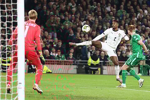Ireland's Liam Scales, right, tries to block a shot from Portugal's Nelson Semedo, center, during a World Cup 2026 group F qualifying soccer match between Ireland and Portugal in Dublin.