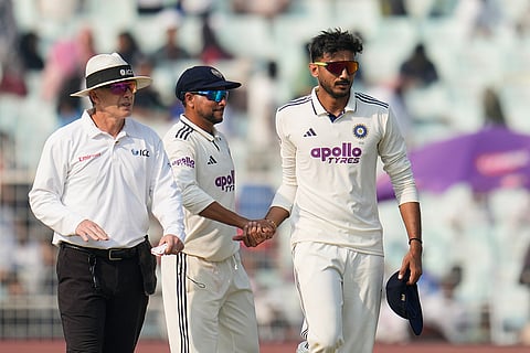 India's Axar Patel, right, celebrates with teammate Kuldeep Yadav after the dismissal of South Africa's Corbin Bosch on the first day of the first cricket test match between India and South Africa in Kolkata.